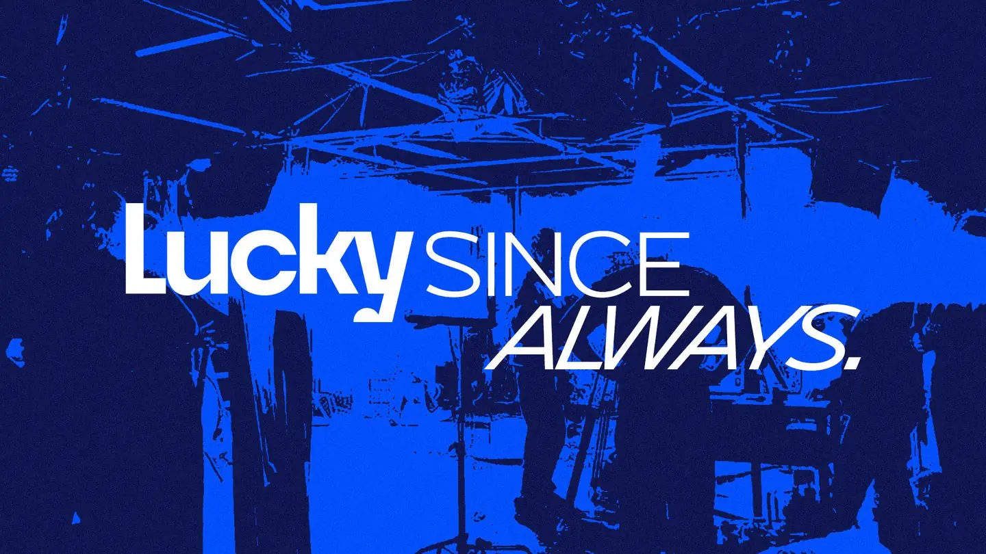 Arte da marca Lucky: bastidor de set em azul com a frase Lucky since always.